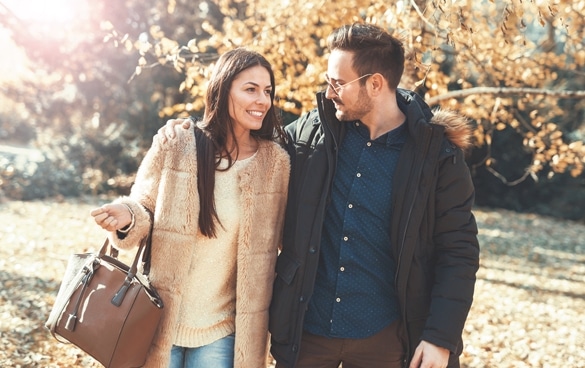 Young embracing loving couple walking through autumn park - Attracting The Taurus Man Through Conversation