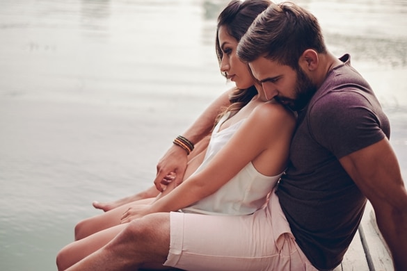 Couple hugging by the river and looking in to water - What Does A Taurus Man Like In An Aquarius Woman