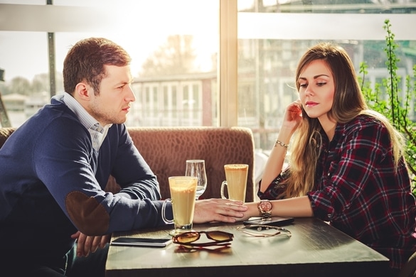 Sad romantic couple holding hands at coffee shop - Taurus Man And Aries Woman Breakup